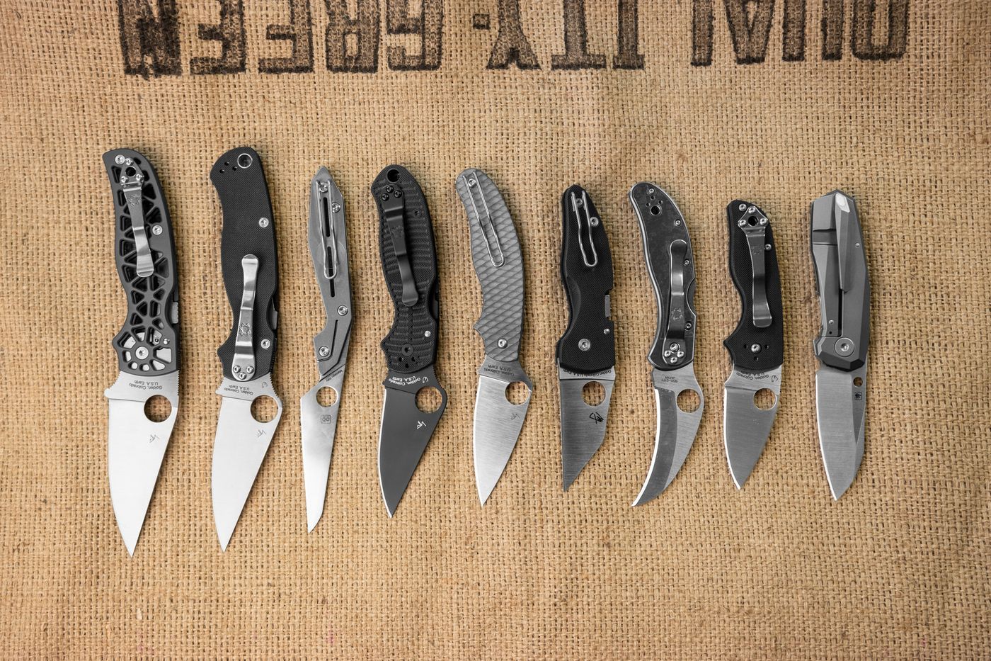 Row of nine different Spyderco knives side by side